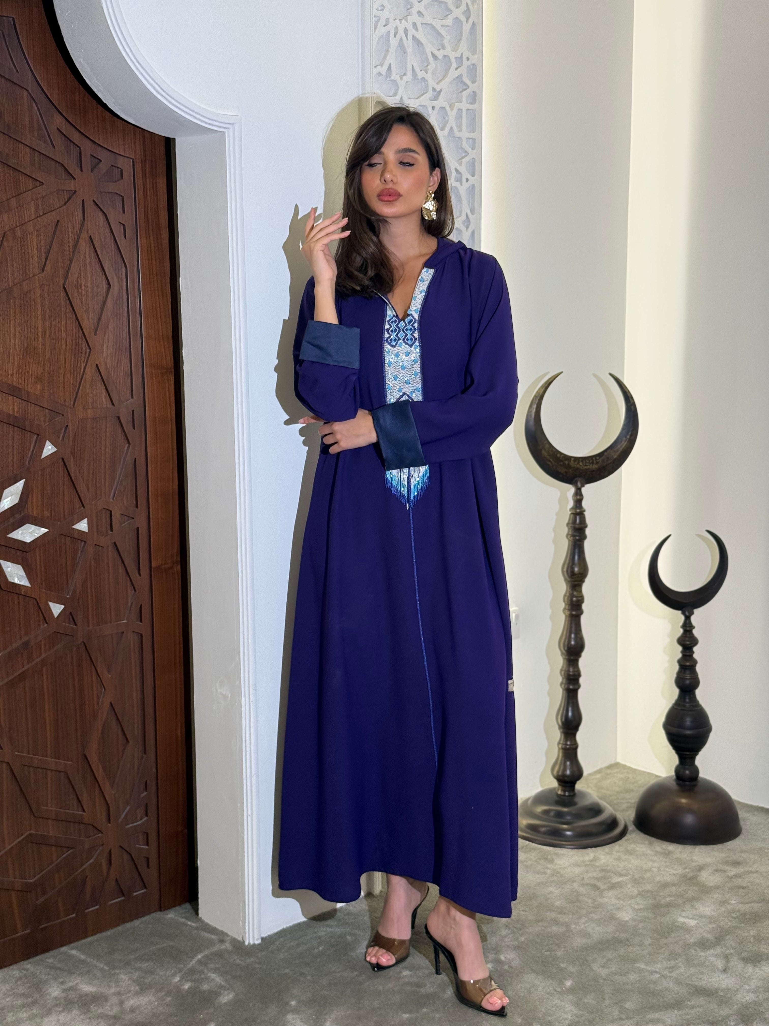 جلابيات من الكريب بلونين، بنفسجي داكن مع تفاصيل زرقاء، تتميز بتطريز دقيق بالخرز (على الطلب)