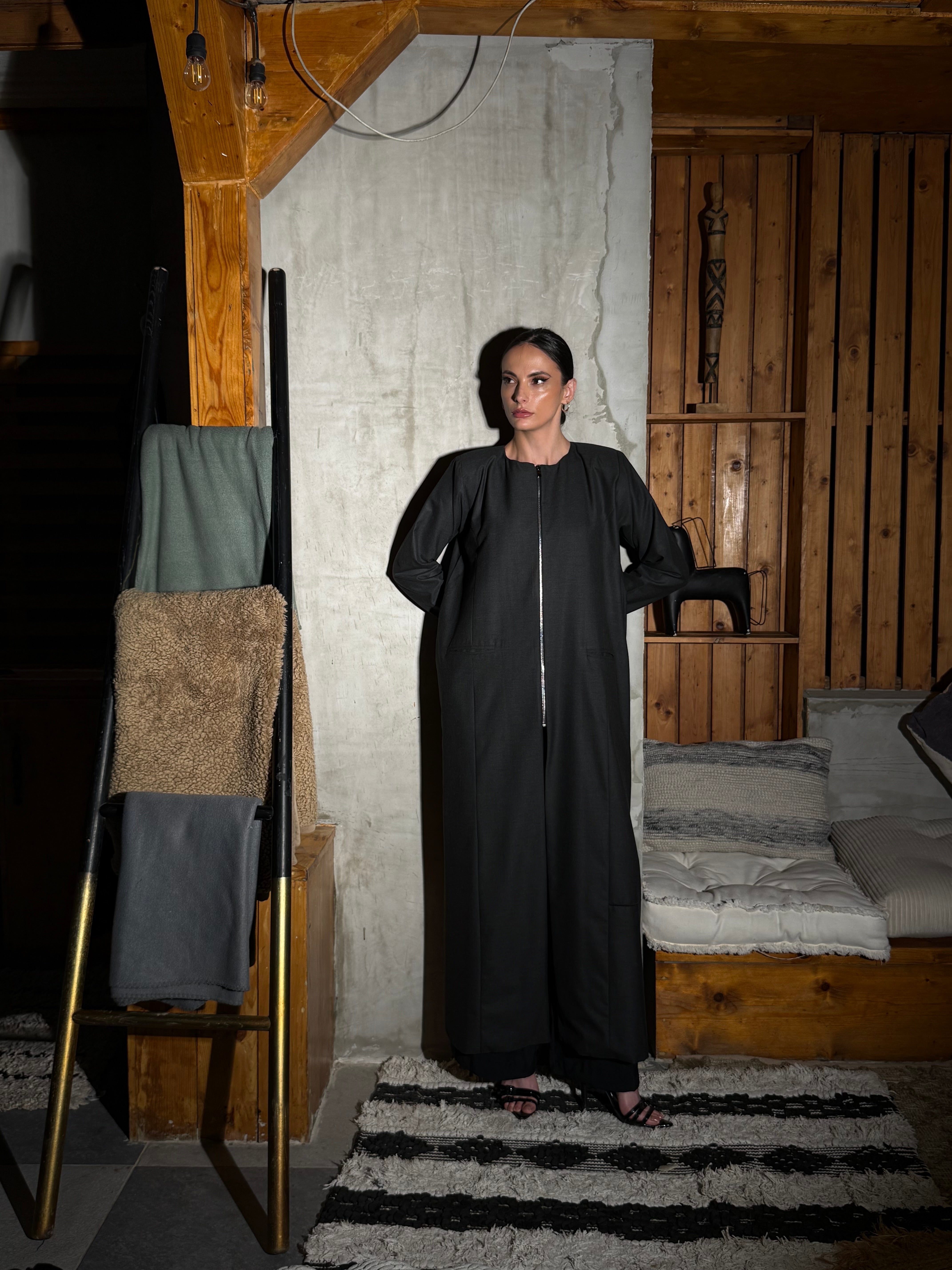 A winter wool-crepe blazer with a zip closure, padded shoulders, side and back vents, and functional pockets.